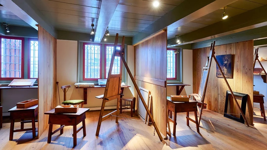 Rembrandt House Museum interior with easels and wooden furniture.