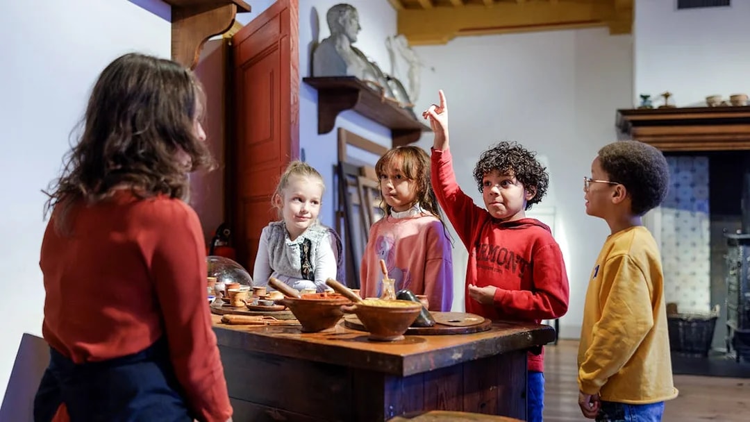 Children engaging with a guide at Rembrandt House Museum, Amsterdam.