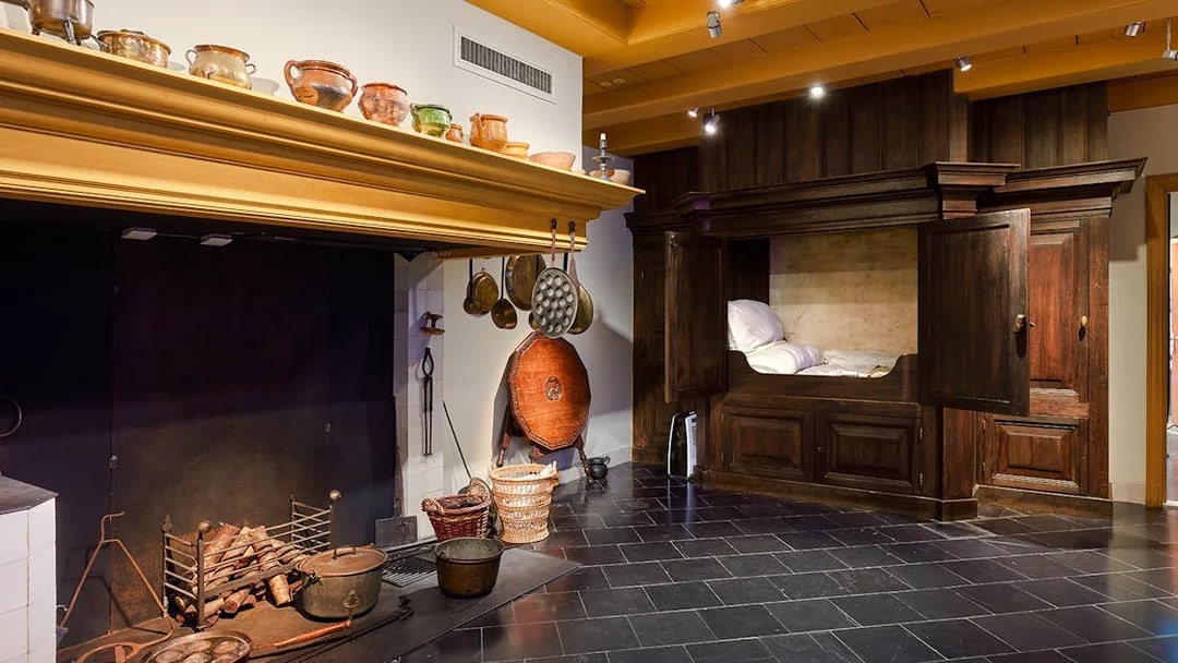 Rembrandt House Museum interior with historic kitchen and wooden bed alcove.