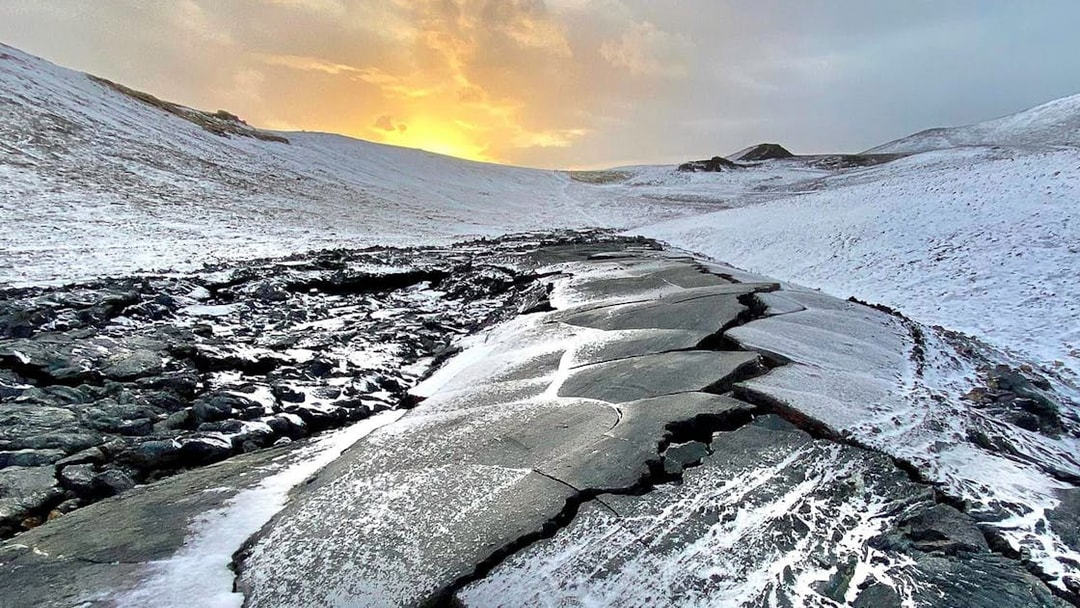 Volcanic landscape with snow-covered lava field at sunset, Reykjanes Peninsula, Iceland.