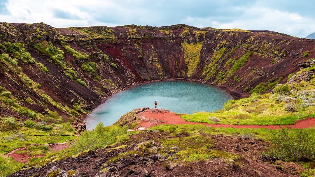 Kerid Crater with turquoise water and red volcanic rock in Iceland.