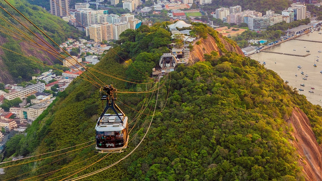 Tourists in Sugarloaf Mountain cable car viewing Rio de Janeiro cityscape.