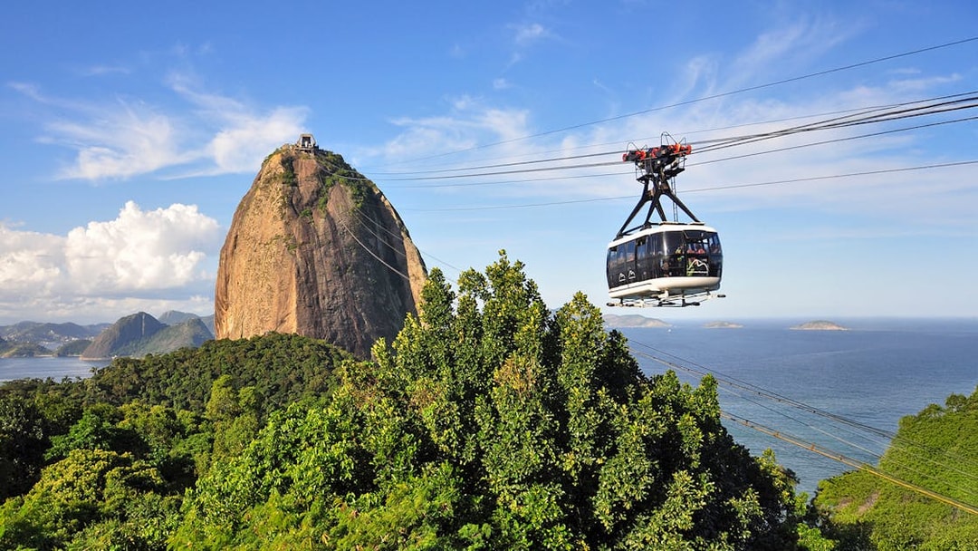 Cable car ascending to Sugarloaf Mountain, Rio de Janeiro, with ocean view.