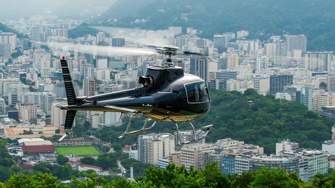 Helicopter taking off over Rio de Janeiro cityscape.