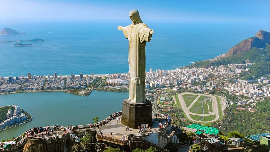 Christ the Redeemer statue overlooking Rio de Janeiro with cityscape and ocean.