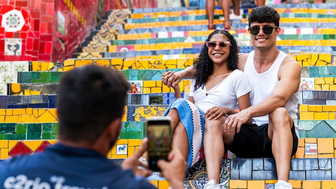 Couple posing on colorful Selarón Steps in Rio de Janeiro.
