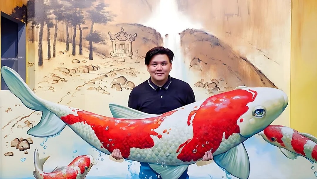 Man holding large koi fish sculpture at Ripley’s Adventureland exhibit.
