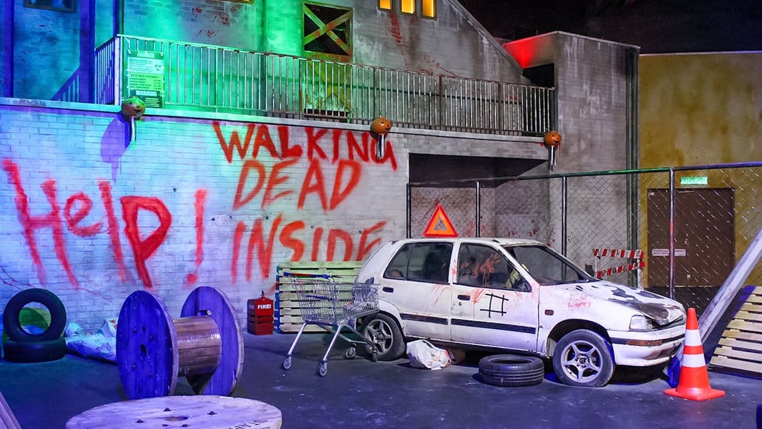Graffiti-covered wall and abandoned car at Ripley’s Adventureland.