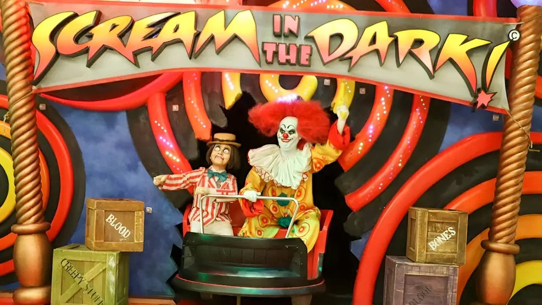 Clown figures in a ride at Ripley's Believe It Or Not! Museum with "Scream in the Dark" sign.