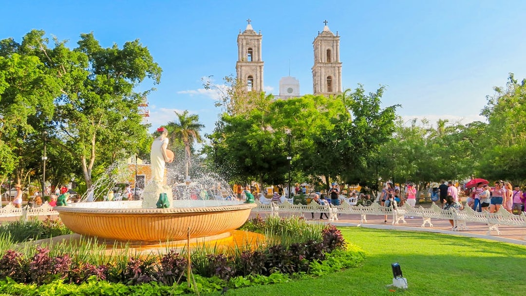 Fountain in a park with the Church of Valladolid, Yucatan, Mexico in the background.