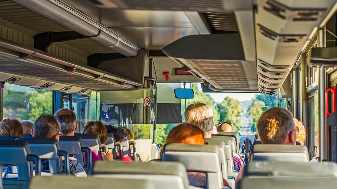 Passengers seated in an air-conditioned coach during a scenic tour.