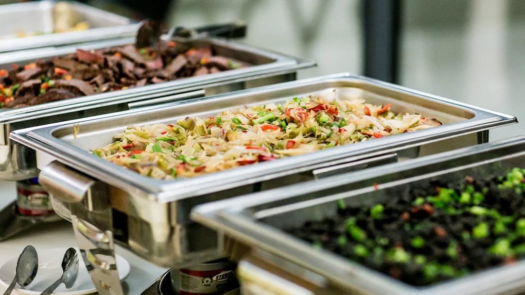 Buffet trays with assorted dishes for tour lunch.