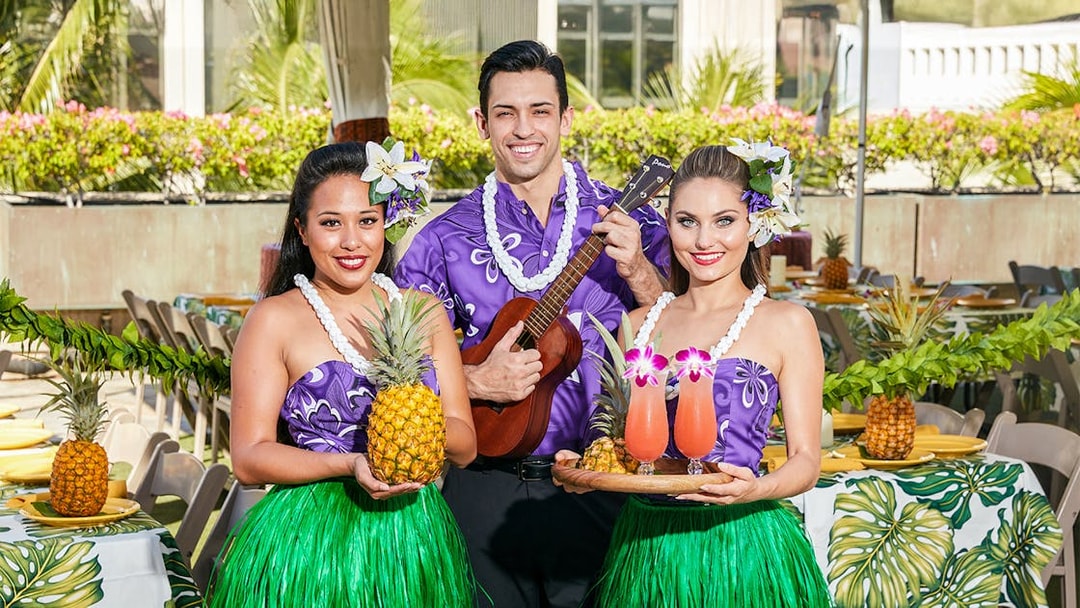 Staff with welcome drinks and pineapples before the Rock-A-Hula Show in Hawaii.