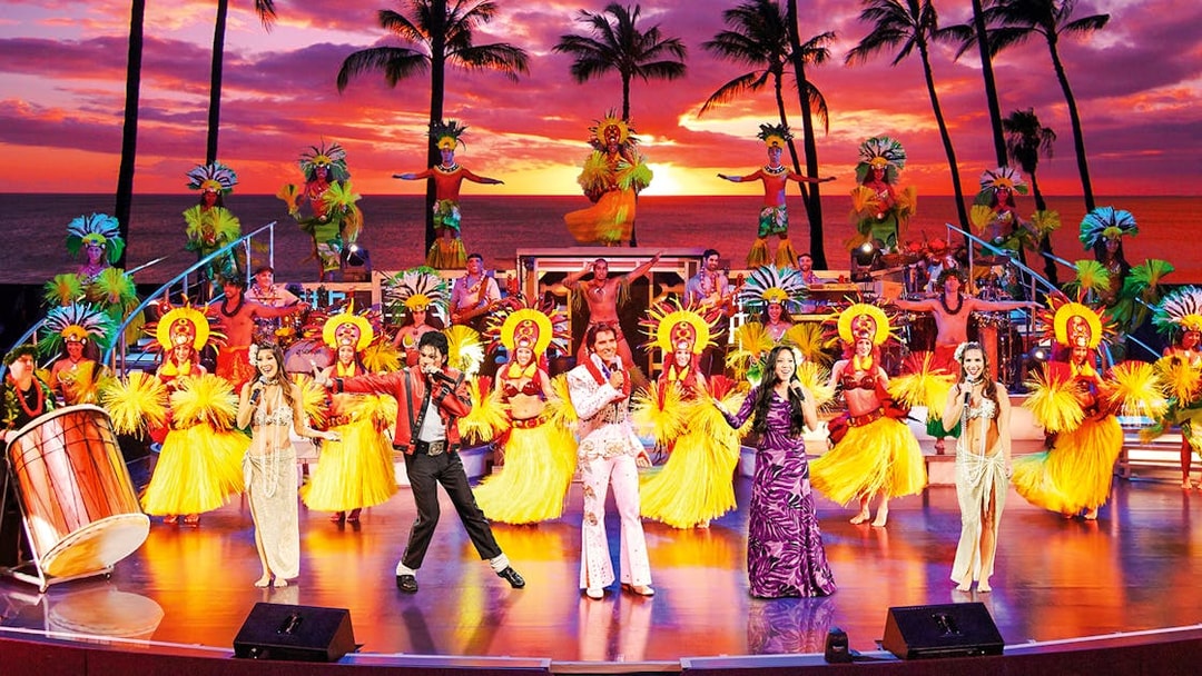 Performers in traditional Hawaiian attire on stage at RockAHula Show, Honolulu.