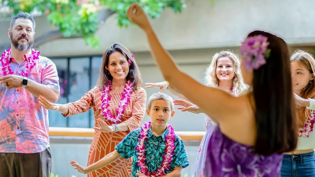 Guests learning hula dance from instructor before Rock-A-Hula show in Hawaii.