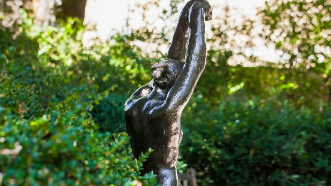 Sculpture in Rodin Museum garden surrounded by greenery.