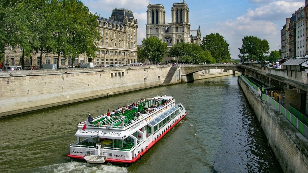 Seine River cruise boat near Notre-Dame Cathedral in Paris.