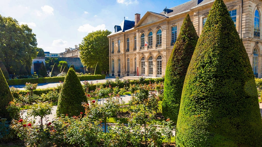 Rodin Museum Gardens with manicured hedges and historic building in Paris.