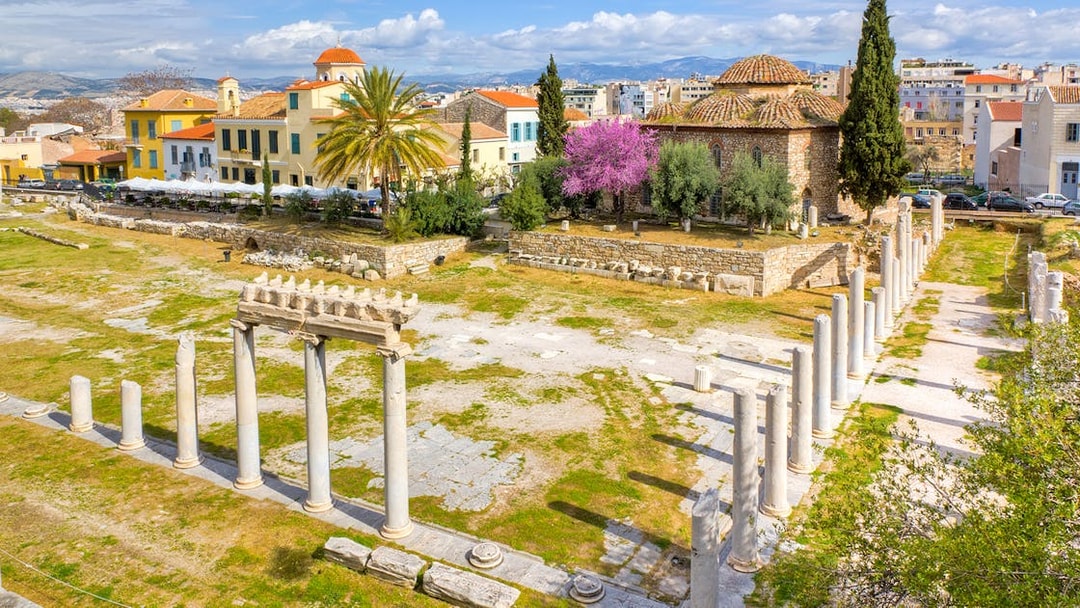 Roman Agora ruins with columns and ancient structures in Athens, Greece.