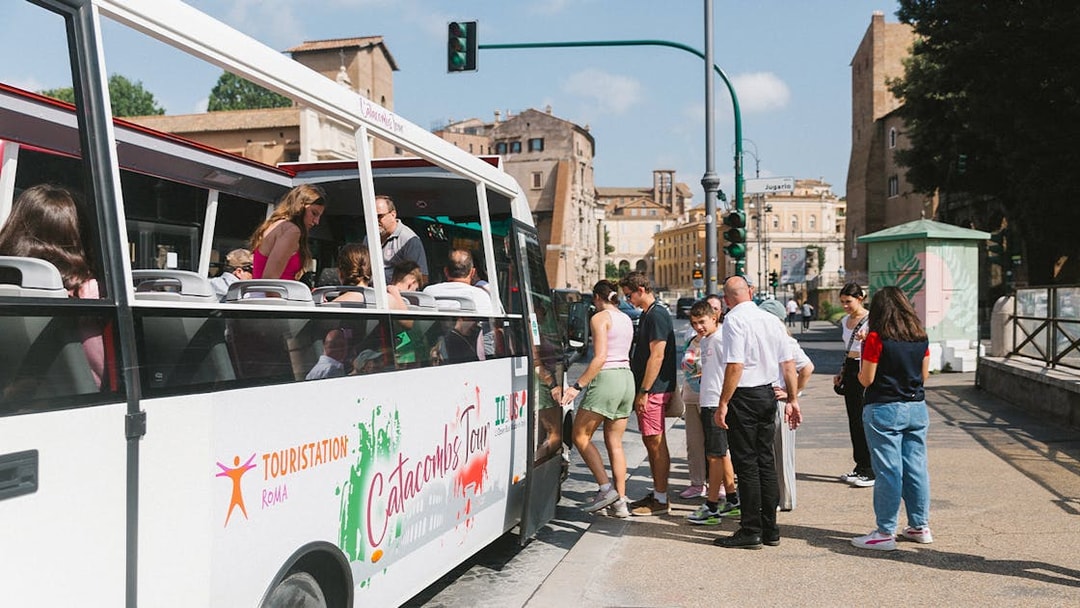 Tourists boarding a bus for a guided tour of the Catacombs in Rome.