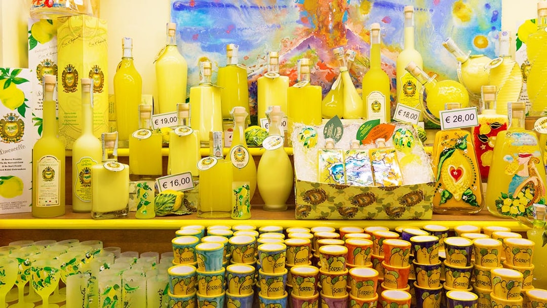 Limoncello bottles and souvenirs on display in Amalfi shop during full-day tour from Rome.