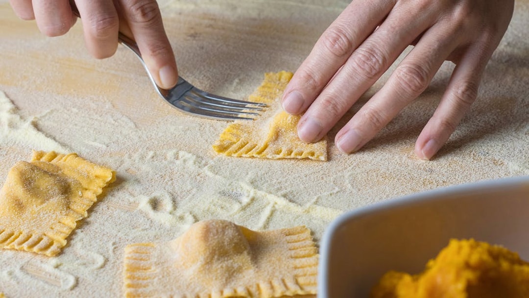 Ravioli being shaped with a fork during a cooking class in Rome.