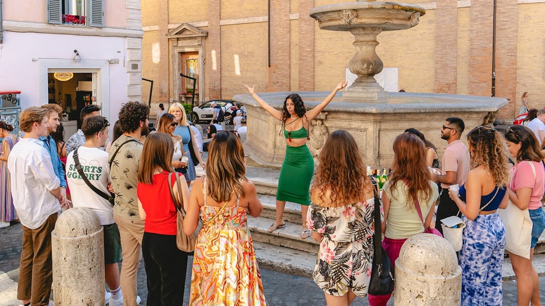 Tourists gathered around a guide at a fountain in Rome's Monti neighborhood.