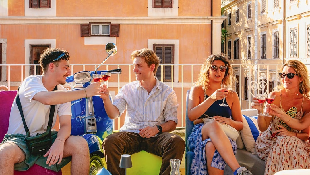 Group of friends enjoying drinks on a terrace in Rome.
