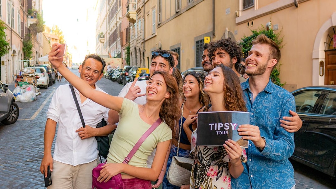 Group taking a selfie on a Rome guided tour in a cobblestone street.
