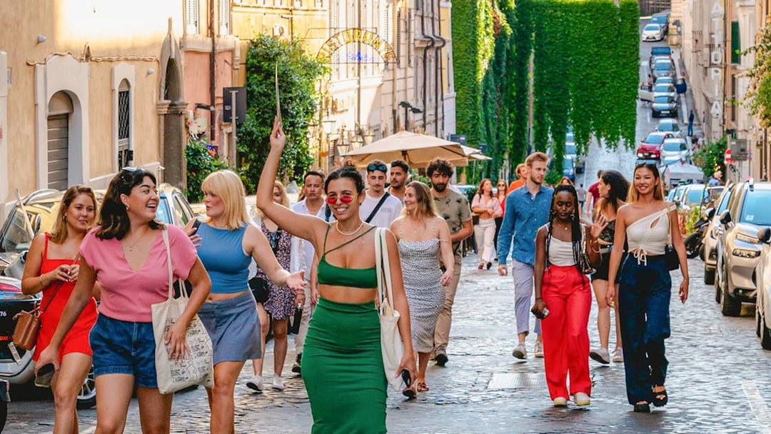 Tourists walking on a cobblestone street in Rome.