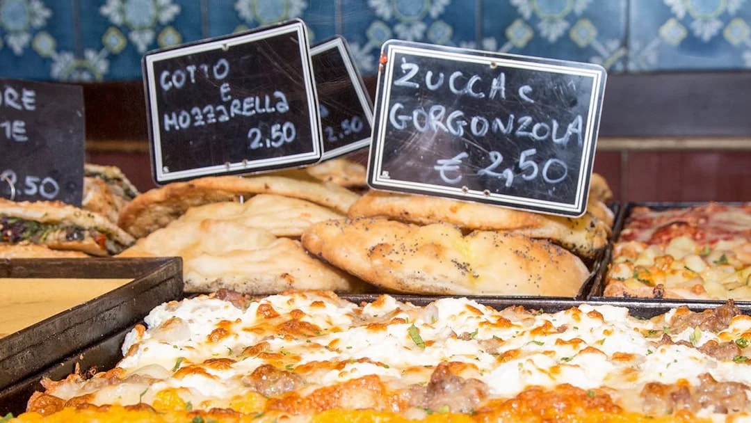 Italian focaccia and pizza with mozzarella and gorgonzola on display in a bakery.