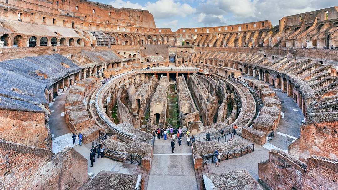 Tourists exploring the Colosseum's underground chambers in Rome with the Rome Super Pass.