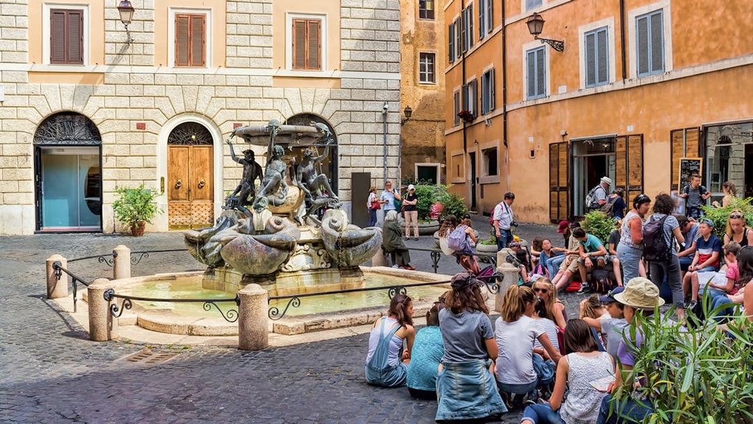 People gathered around Fontana delle Tartarughe in Rome's Piazza Mattei.