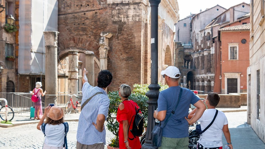 Tourists exploring ancient ruins on a walking tour of Rome's Jewish Ghetto.