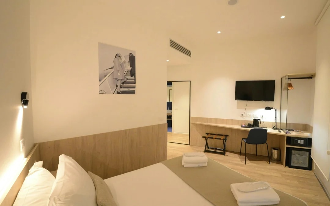 Modern lounge room with bed, desk, and TV at Plaza Premium Lounge, Terminal 1, Fiumicino Airport, Rome.