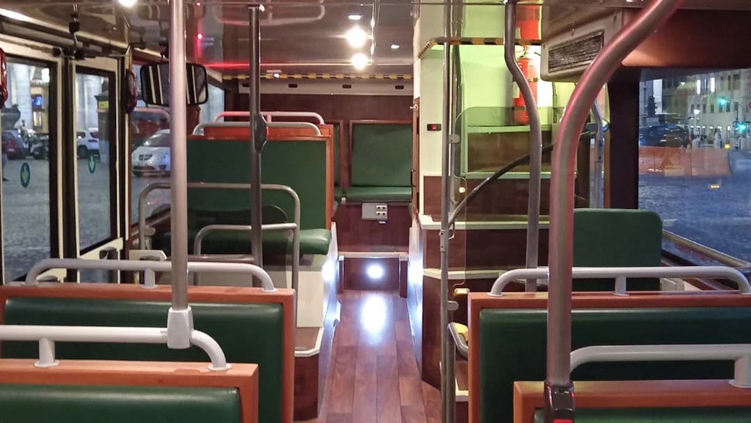 Vintage bus interior with green seats and wooden accents.