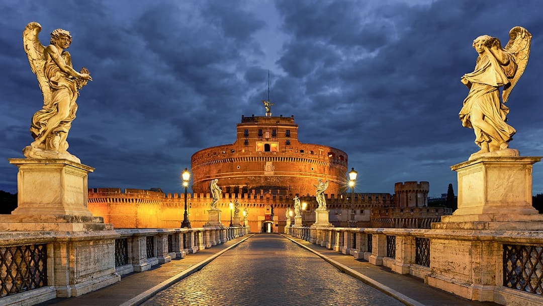 Castel Sant'Angelo in Rome with angel statues on the bridge at dusk.