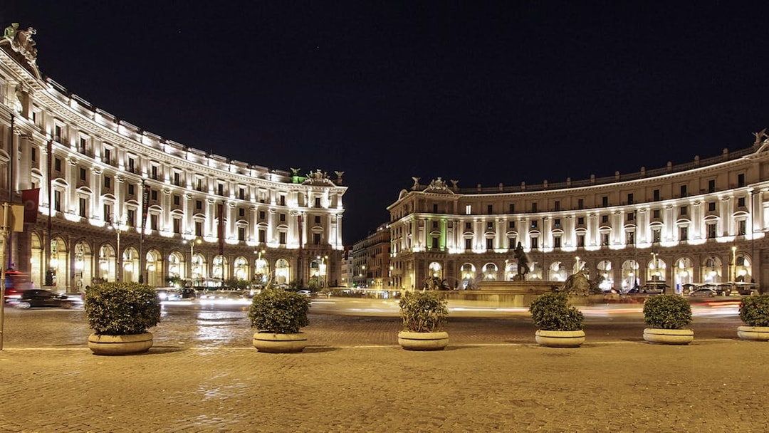 Republic Square in Rome, Italy, illuminated at night with historic buildings and a central fountain.