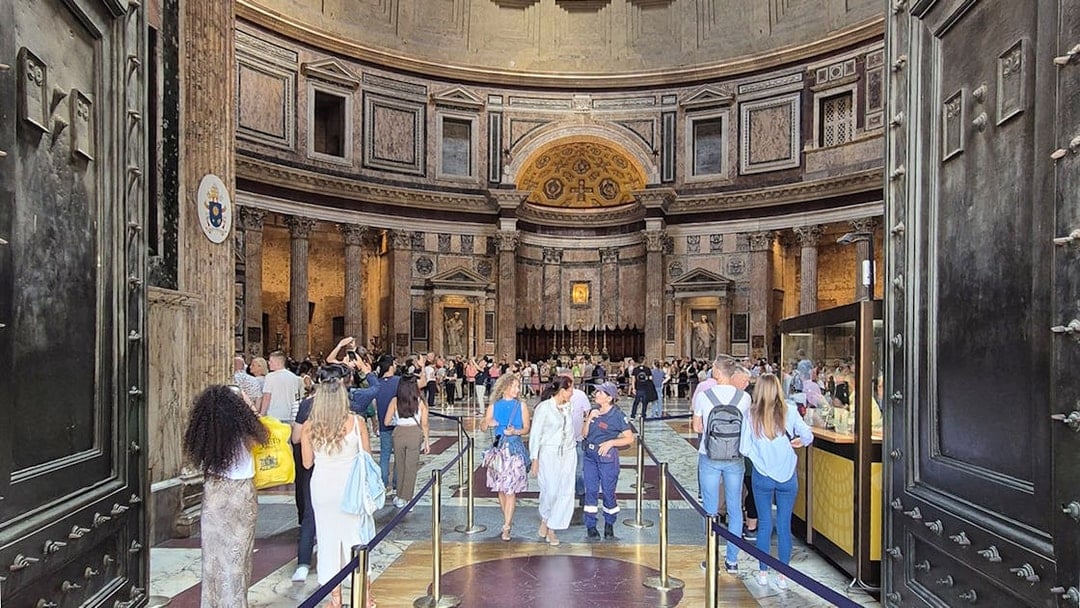 Tourists exploring the interior of the Rome Pantheon, an ancient Roman temple.