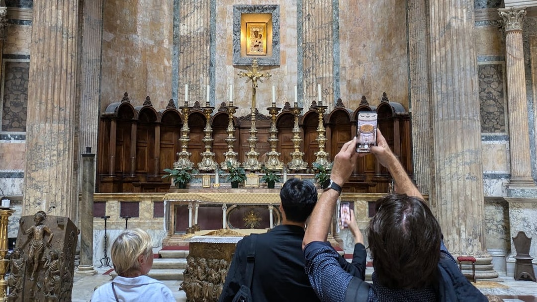 Visitors photographing the altar inside the Pantheon in Rome.