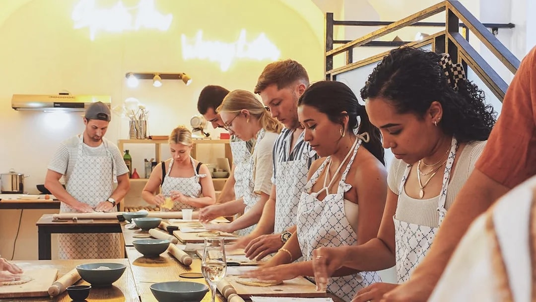 Participants making pasta at a cooking class in Italy.