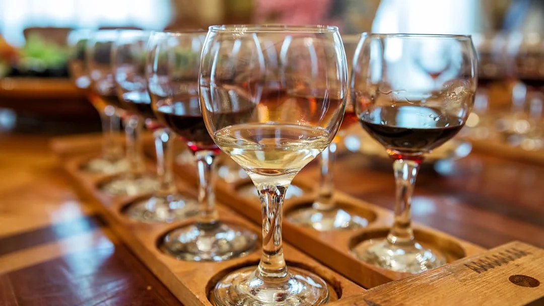 Different types of wine glasses arranged on a wooden tray.
