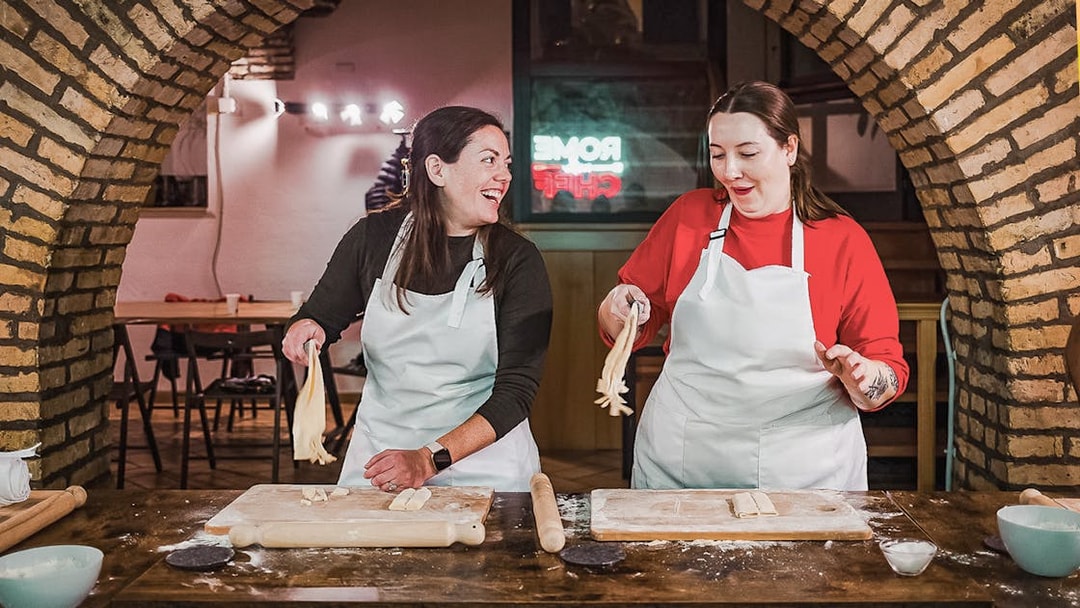 Two people making pasta in a cooking class in Rome.