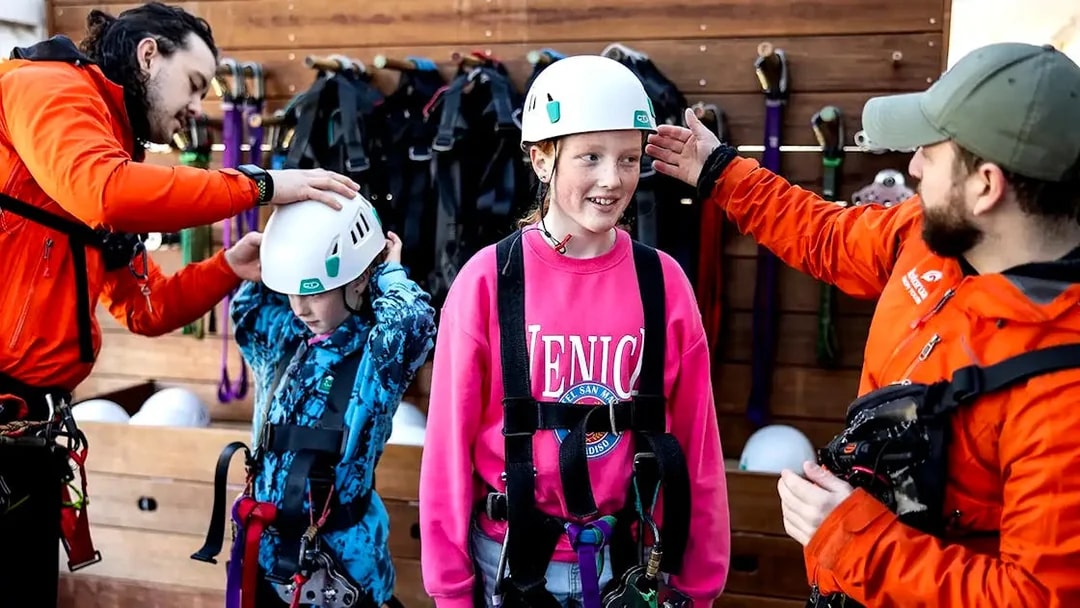 Children preparing for Rotorua Forest Zipline Tour with helmets and harnesses.