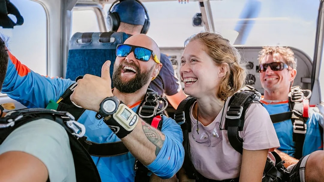 Skydivers smiling inside plane before tandem jump, Rottnest Island.