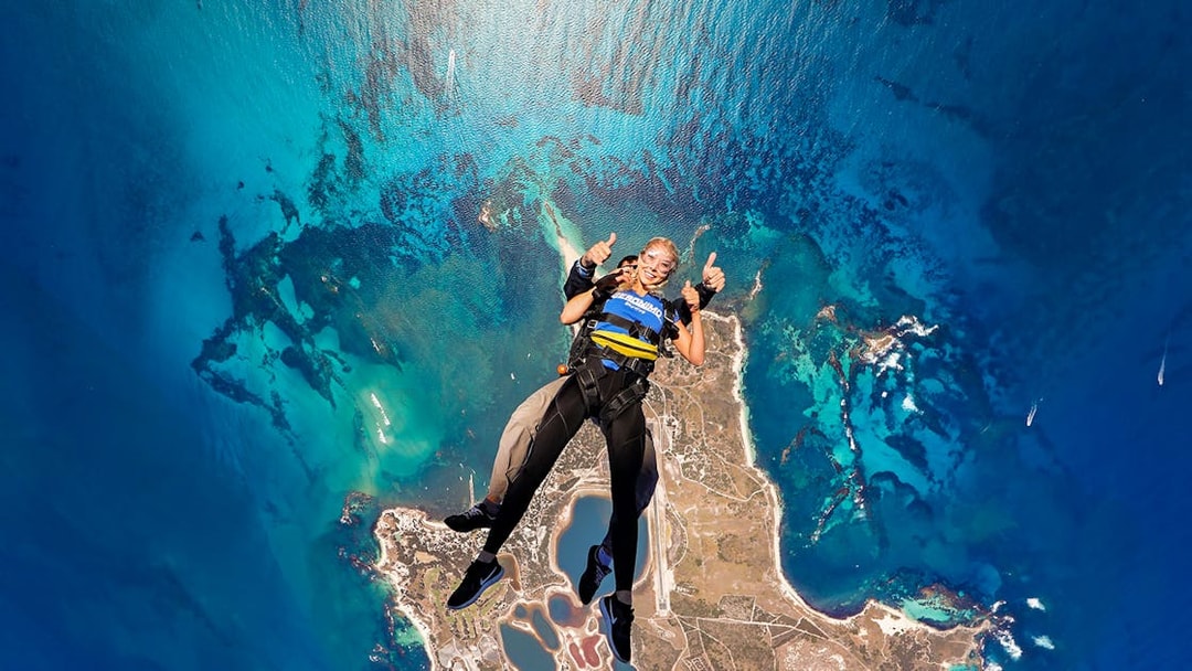 Tandem skydive over Rottnest Island, Perth, with aerial view of coastline and ocean.