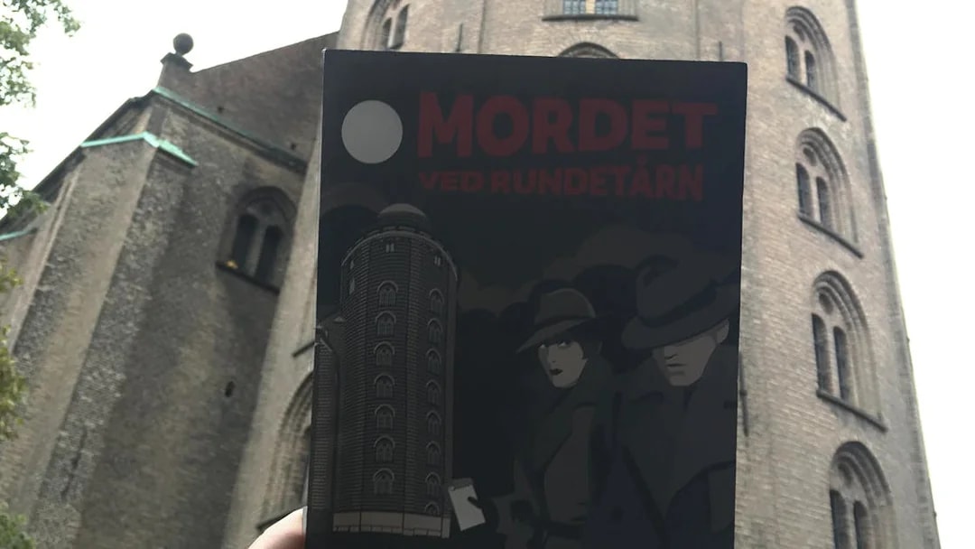 Murder Mystery Experience poster held in front of Round Tower, Copenhagen.