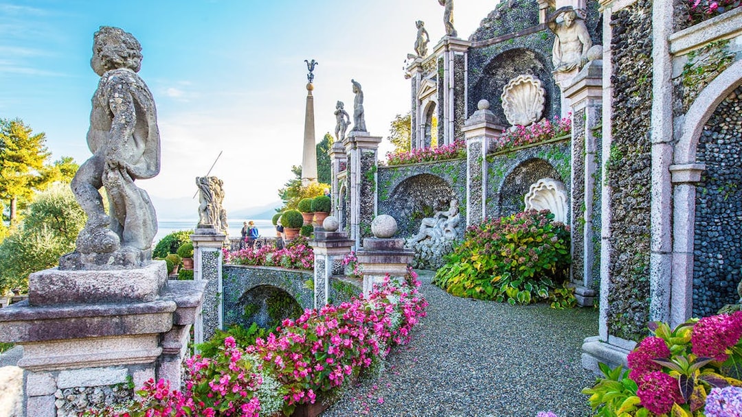 Statues and gardens at Isola Bella, Italy, with lake view in background.