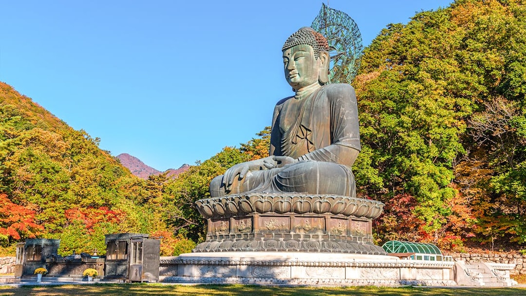 Buddha statue surrounded by autumn trees at Seoraksan National Park, Republic of Korea.