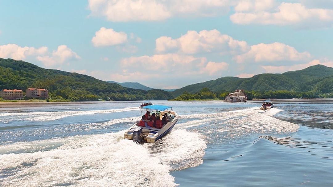 Boats cruising on the water with scenic views of Nami Island's lush hills.